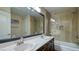 Bathroom featuring double sinks, a large mirror, and a shower-over-tub combo with tile surround at 5820 Amber Station Ave, Las Vegas, NV 89131