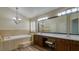 An elegant bathroom with wood cabinets, double sinks, a garden tub, and modern lighting at 5820 Amber Station Ave, Las Vegas, NV 89131