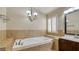 The bathroom has a soaking tub with tile surround, shuttered window, and modern fixtures at 5820 Amber Station Ave, Las Vegas, NV 89131