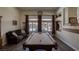 An entertainment room with a pool table, plush sofa, and a view of the backyard at 5820 Amber Station Ave, Las Vegas, NV 89131