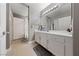Bright bathroom with white cabinets, large mirror, and shower with decorative curtain at 59 E Agate Ave # 306, Las Vegas, NV 89123