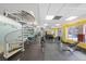 Bright community gym with modern equipment, yellow walls, and a spiral staircase near windows at 59 E Agate Ave # 306, Las Vegas, NV 89123
