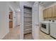 A view of a laundry room, with shelving and access to the washing machine and dryer at 6116 Tokara Ave, Las Vegas, NV 89122