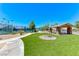 Well-maintained tennis courts with a shaded seating area and manicured lawn at 6116 Tokara Ave, Las Vegas, NV 89122