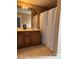 Bathroom with dual vanity sinks, large mirror, and shower with a patterned curtain at 6495 Chettle House Ln, Las Vegas, NV 89122
