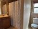 Bathroom with vanity, mirror, toilet, and patterned shower curtain at 6495 Chettle House Ln, Las Vegas, NV 89122