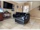 Living room featuring modern tile floors, contemporary leather sofa, and neutral wall colors at 6495 Chettle House Ln, Las Vegas, NV 89122