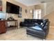 Cozy living room with leather sectional sofa, tiled floor, and a large flat screen TV for entertainment at 6495 Chettle House Ln, Las Vegas, NV 89122