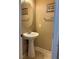 Neat half-bathroom featuring a pedestal sink, decorative mirror, and tiled flooring for convenience at 6495 Chettle House Ln, Las Vegas, NV 89122
