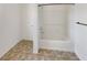 Bathroom featuring a tub/shower combo, tile flooring, and a clean, minimalist design at 7011 Overton St, Las Vegas, NV 89166