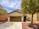 Welcoming single-story home with a two-car garage, complemented by a beautifully landscaped front yard at 7011 Overton St, Las Vegas, NV 89166