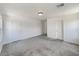 Neutral colored room featuring carpeted floor, white walls, white doors, and a ceiling light fixture at 7011 Overton St, Las Vegas, NV 89166