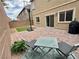 Cozy brick-paved patio area with outdoor seating and a grill, perfect for entertaining in the backyard at 7041 Fossil Rim St, North Las Vegas, NV 89084