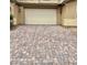 Paver driveway leading to a two-car garage, complemented by manicured landscaping at 7041 Fossil Rim St, North Las Vegas, NV 89084