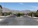 Gated community entrance featuring iron gates, stone pillars, and a stunning mountain backdrop at 7041 Fossil Rim St, North Las Vegas, NV 89084