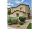 Two story tan home featuring manicured landscaping, including nice shrubbery and desert rock at 7041 Fossil Rim St, North Las Vegas, NV 89084
