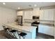 Bright kitchen featuring a granite island with bar stool seating and stainless steel appliances at 7041 Fossil Rim St, North Las Vegas, NV 89084