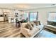 Open-concept living space with hardwood floors, a modern kitchen, and a comfortable sofa with decorative pillows at 7041 Fossil Rim St, North Las Vegas, NV 89084