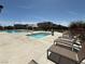 Outdoor pool and jacuzzi with several lounge chairs and well kept landscaping under a blue sky at 7041 Fossil Rim St, North Las Vegas, NV 89084