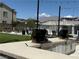 Outdoor barbecue area featuring two stainless steel grills and several lounge chairs near the pool at 7041 Fossil Rim St, North Las Vegas, NV 89084