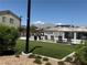 Community pool area featuring an artificial turf lawn, lounge chairs and umbrellas at 7041 Fossil Rim St, North Las Vegas, NV 89084