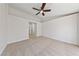 Bedroom with neutral carpet, ceiling fan and an open doorway to the bathroom at 7441 Aurora Glow St, Las Vegas, NV 89139