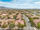 An aerial view showcases a vibrant community nestled with tree-lined streets and mountain views at 7716 Twin Tails St, Las Vegas, NV 89149