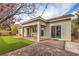 A covered patio overlooks an expertly designed backyard, combining brick pavers, turf, and desert landscaping at 7716 Twin Tails St, Las Vegas, NV 89149