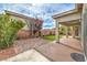 This backyard offers a blend of brick paving, artificial turf, and a covered patio with ceiling fan at 7716 Twin Tails St, Las Vegas, NV 89149