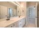 Spacious bathroom with double sinks, white cabinets, and views to bedroom at 7716 Twin Tails St, Las Vegas, NV 89149