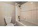 Bathroom featuring a toilet, shower-tub combination, and tiled walls at 7716 Twin Tails St, Las Vegas, NV 89149