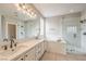 Bright bathroom featuring a double sink vanity, soaking tub and glass enclosed shower at 7716 Twin Tails St, Las Vegas, NV 89149