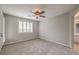 Neutral bedroom with a ceiling fan and bright, shuttered windows at 7716 Twin Tails St, Las Vegas, NV 89149