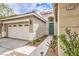Close up of a home featuring a decorative front door, desert landscaping, and two-car garage at 7716 Twin Tails St, Las Vegas, NV 89149