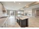 Open kitchen design with island, stainless gas range, and adjacent living spaces at 7716 Twin Tails St, Las Vegas, NV 89149
