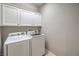 Bright laundry room with modern Samsung washer and dryer and white storage cabinets at 7716 Twin Tails St, Las Vegas, NV 89149
