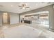 Open-concept living room featuring an island kitchen, tile floors, and a ceiling fan at 7716 Twin Tails St, Las Vegas, NV 89149