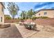 Backyard with a patio area, a built-in fire pit, a hot tub, desert landscaping, and a privacy fence at 7898 Red Rock Ridge Ave, Las Vegas, NV 89179