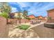 Inviting backyard featuring a stone patio with a fire pit, hot tub, and low-maintenance desert landscaping at 7898 Red Rock Ridge Ave, Las Vegas, NV 89179