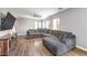 Spacious living room with hardwood floors, grey walls, large windows, and a comfortable sectional couch at 7898 Red Rock Ridge Ave, Las Vegas, NV 89179