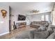Spacious living room with hardwood floors, grey walls, large windows, and a comfortable sectional couch at 7898 Red Rock Ridge Ave, Las Vegas, NV 89179
