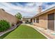 Well maintained backyard with artificial grass, mature landscaping, and covered patio at 805 Blue Springs Dr, Henderson, NV 89002
