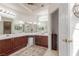 Bright bathroom with double sinks, wood cabinets, decorative mirror, and neutral color palette at 805 Blue Springs Dr, Henderson, NV 89002