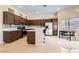 Well-lit kitchen featuring dark wood cabinetry, stainless steel appliances, and an eat-in island at 8141 Guava Nectar Ave, Las Vegas, NV 89131