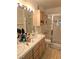 Bathroom featuring double sinks, a large mirror, tiled floors, and a glass door shower at 8452 Boseck Dr # 216, Las Vegas, NV 89145