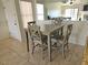 Dining area showcasing a gray table, four chairs, and neutral tile flooring at 8452 Boseck Dr # 216, Las Vegas, NV 89145