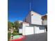The townhouse has three garage doors and a small side patio at 8452 Boseck Dr # 216, Las Vegas, NV 89145