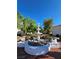 Beautiful courtyard featuring an ornate, tiered fountain surrounded by lush landscaping and brick pavers at 8452 Boseck Dr # 216, Las Vegas, NV 89145