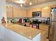 Well-lit kitchen featuring tan cabinets, granite countertops, and stainless steel appliances at 8452 Boseck Dr # 216, Las Vegas, NV 89145