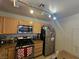 Well-lit kitchen featuring tan cabinets, granite countertops, and stainless steel appliances at 8452 Boseck Dr # 216, Las Vegas, NV 89145
